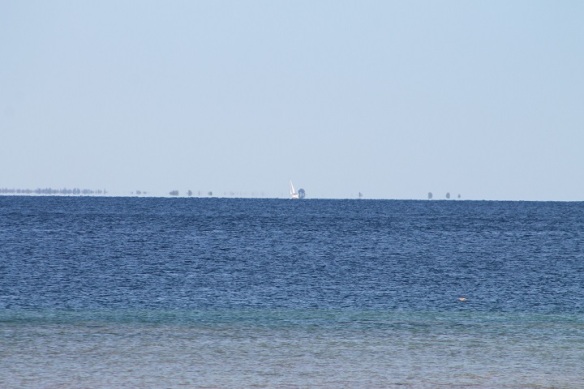 Ok.  Here's a mystery I wish someone would help me with.  About 1/2 mile before I reached Arch Rock I saw - way out on the horizon - a sailboat.  To the left was what looked like trees.  The mystery is: what are the images out in the water around the sailboat?  I don't think it's land, and I don't think it could be other boats.  This photo was using my long lens zoomed as far out as it would go . . . .